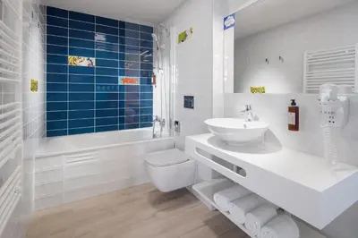 a white bathroom with a sink and a toilet at Comfort Hotel Prague City in Prague