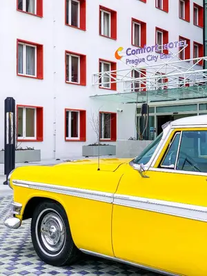 a yellow car parked in front of a building at Comfort Hotel Prague City in Prague