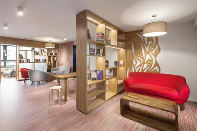 a living room with a red couch and a table at Comfort Hotel Prague City in Prague