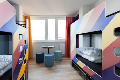 a bedroom with two bunk beds and a table at a&o Prague Rhea in Prague