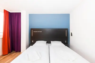 a bedroom with two beds and colorful curtains at a&o Prague Rhea in Prague
