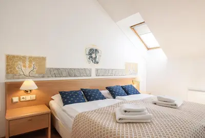 a bedroom with two beds with towels on them at Hotel Tivoli Prague in Prague