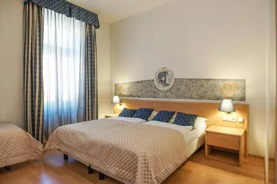 a bedroom with a large bed and a window at Hotel Tivoli Prague in Prague