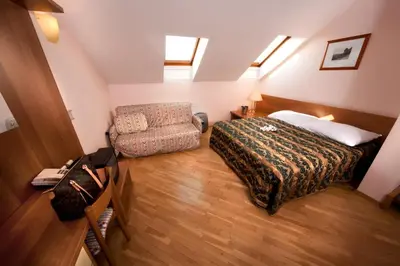 a small bedroom with a bed and a chair at Hotel Residence Select in Prague