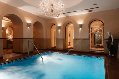 a large swimming pool in a room with a chandelier at Alchymist Grand Hotel and Spa in Prague