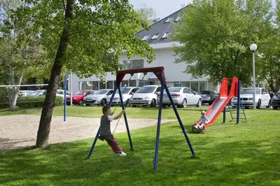 a young boy playing on a swing set in a park at Hotel Michael in Prague