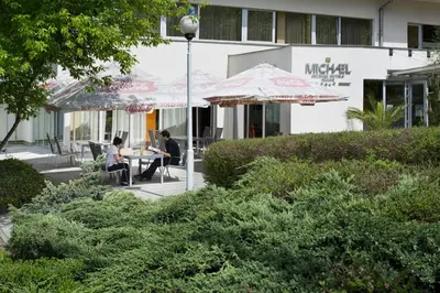 two people sitting at a table under an umbrella at Hotel Michael in Prague