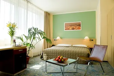 a hotel room with a bed and a table with fruit on it at Hotel Michael in Prague