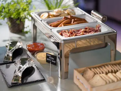 a buffet with hot dogs and other food on a table at Hotel Michael in Prague