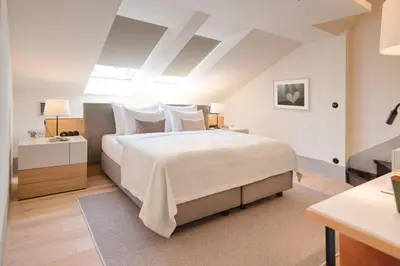 a bedroom with a large bed with white sheets and pillows at Hotel BOOKQUET in Prague