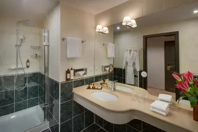 a bathroom with a sink and a shower and a tub at Hotel BOOKQUET in Prague