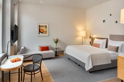 a hotel room with two beds and a couch at Hotel BOOKQUET in Prague
