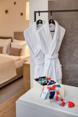 a room with a bed and a white robe and a box at Hotel BOOKQUET in Prague