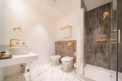 a bathroom with a shower and a toilet and a sink at Hotel BOOKQUET in Prague