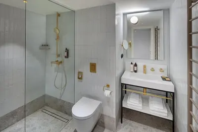 a bathroom with a toilet and a sink and a shower at Hotel BOOKQUET in Prague