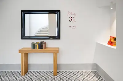 a mirror on a wall next to a table with books at Hotel BOOKQUET in Prague