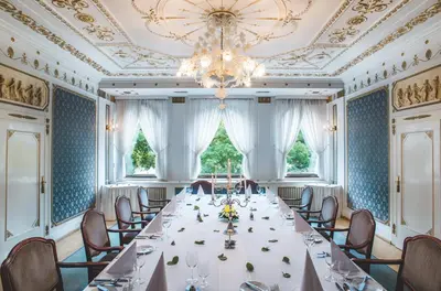 a long table in a room with a chandelier at Esplanade Hotel Prague in Prague