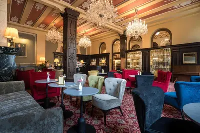 a restaurant with tables and chairs and chandeliers at Esplanade Hotel Prague in Prague