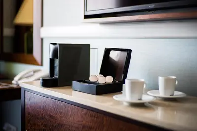 a counter with a coffee maker and two cups on it at Esplanade Hotel Prague in Prague