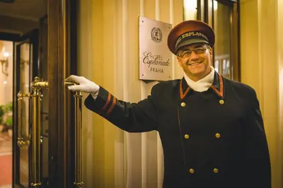 a man in a uniform is opening a door at Esplanade Hotel Prague in Prague
