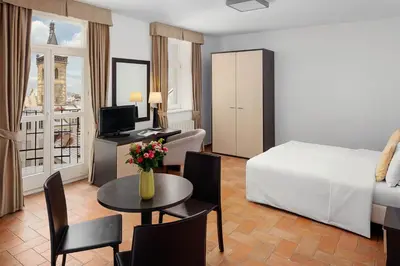 a hotel room with a bed and a table and chairs at Hotel Praga 1 in Prague