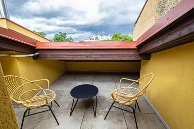 a balcony with two chairs and a table on a building at Quite Loft with Balcony and 3 Air Conditioners in Prague
