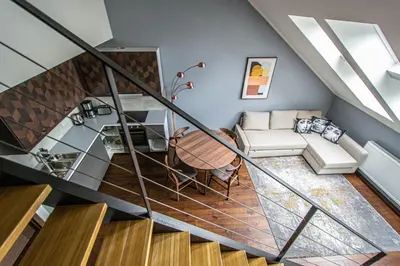 a room with a staircase with a couch and a table at Quite Loft with Balcony and 3 Air Conditioners in Prague