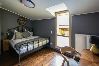 a bedroom with a bed and a table and a chair at Quite Loft with Balcony and 3 Air Conditioners in Prague