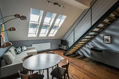 a living room with a table and a staircase at Quite Loft with Balcony and 3 Air Conditioners in Prague