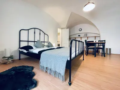 a bedroom with a bed and a table in a room at Studio Nicolas II Prague in Prague