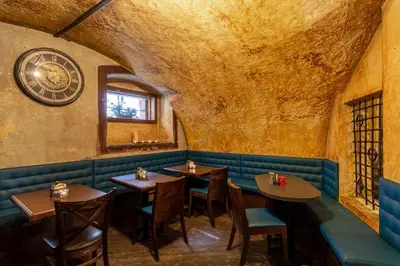 a restaurant with tables and a clock on the wall at Studio Nicolas II Prague in Prague