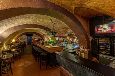 a bar with a row of tables and chairs in a building at Studio Nicolas II Prague in Prague