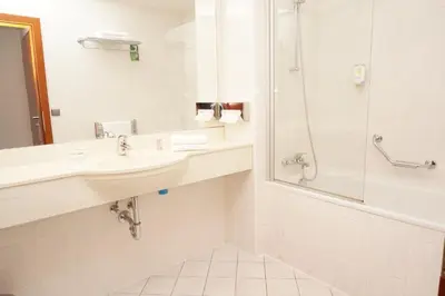 a bathroom with a sink and a shower at Hotel Coronet in Prague