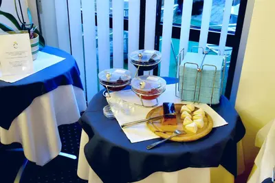 a blue table with a plate of food and wine glasses at Hotel Coronet in Prague