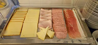 a plastic container filled with different types of meats and cheese at Hotel Coronet in Prague