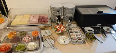 a table with trays of different types of food at Hotel Coronet in Prague