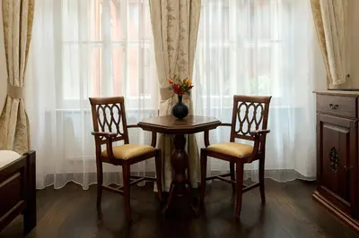a table and two chairs and a vase with flowers on it at Hotel Residence U Černého Orla in Prague