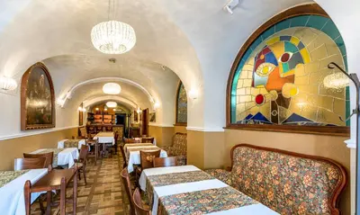 a restaurant with tables and chairs and a stained glass window at Hotel Residence U Černého Orla in Prague