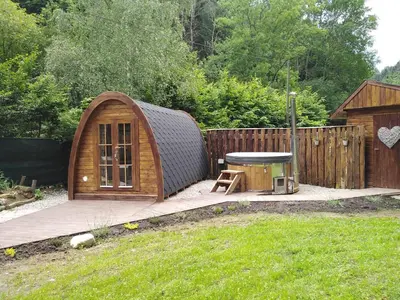 a small wooden hut with a table in a yard at Wellness Kokořín in Kokořín