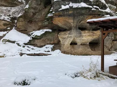 a snow covered yard with a snow covered rock wall at Wellness Kokořín in Kokořín