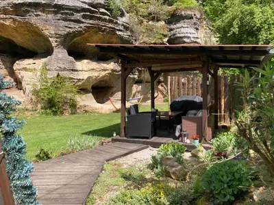 a wooden pergola with a table and chairs in a garden at Wellness Kokořín in Kokořín