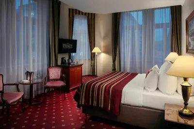 a hotel room with a bed and a table and chairs at Art Nouveau Palace Hotel in Prague
