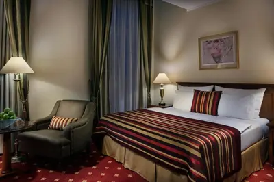 a hotel room with a bed and a chair at Art Nouveau Palace Hotel in Prague