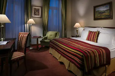 a hotel room with a bed and a desk and a chair at Art Nouveau Palace Hotel in Prague