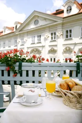 a table with a breakfast of coffee and croissants at Art Nouveau Palace Hotel in Prague