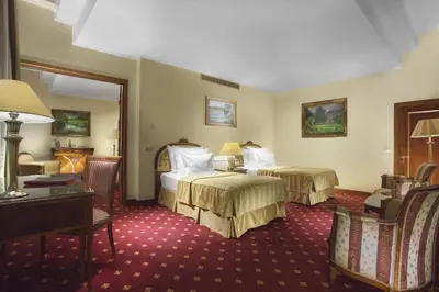 a hotel room with two beds and a desk at Art Nouveau Palace Hotel in Prague