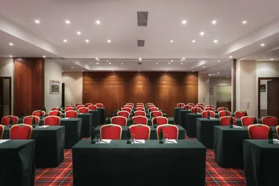 a conference room with desks and red chairs in it at Art Nouveau Palace Hotel in Prague