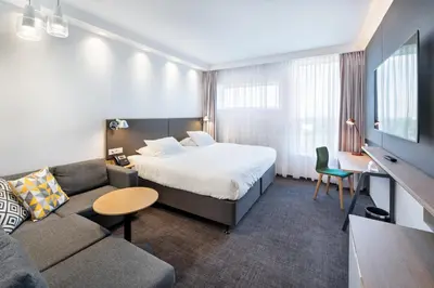 a hotel room with a bed and a couch at Holiday Inn Prague Airport by IHG in Prague