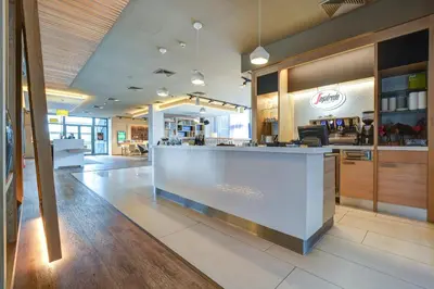 a lobby of a restaurant with a reception counter at Holiday Inn Prague Airport by IHG in Prague