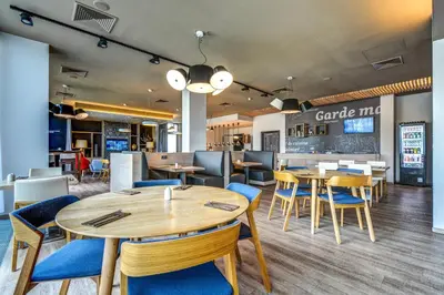 a restaurant with tables and chairs and a bar at Holiday Inn Prague Airport by IHG in Prague